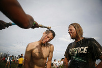 August 2009, New York, N.Y. - Concert goers get hosed off after dancing in a mud pit during the All Points West music festival at Liberty State Park.