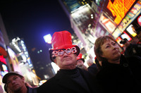December 2007, New York, N.Y. - Jack Ciesemier, center, and his wife Karen, right, of Chicago, Ill., make their way through Times Square as they celebrate New Year's Eve.