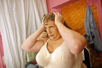 After putting on a padded brassiere, Fierstein adjusts his wig.