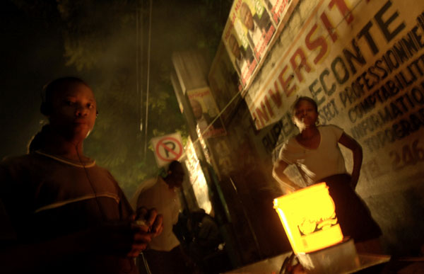 A woman sells fried plantains by night along a road in Delmas. : Haiti 2006 : Jason DeCrow Photojournalist