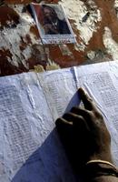 Residents check for their names on a list of election workers in Cite Soleil.