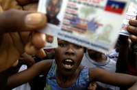 Residents of Cite Soleil, angered by delays at their polling station, take to the streets of Port-au-Prince in protest.