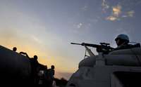 UN peacekeepers watch as Haitians clinging to a tanker truck make their way into Cite Soleil.