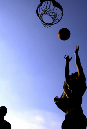 July 2005, Fresh Meadows, N.Y. - The setting sun casts golden light over a game of street basketball at Jewel Park in Fresh Meadows. : Sports Singles : Jason DeCrow Photojournalist