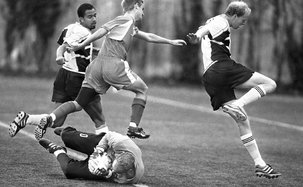 October 2001, Boston, Mass. - Flanked by his own defenders, Towson University goalkeeper Andy Hicks saves a shot on goal from Boston University forward Alan McNamara at BU's Nickerson Field. : Sports Singles : Jason DeCrow Photojournalist