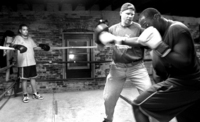 The intensity that made him successful as a pro fighter is what allows David to command the respect of his fighers at the NDYC.  As Louis 
looks on, David drills Pierre Havilland, one of the NDYC's older fighters, on his right cross.