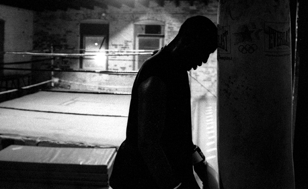 After a round on the heavy bag, Pierre bows his head in exhaustion.  With David gone, it falls on the shoulders of older fighters like Pierre and Kate to lead the younger fighters. : Fighting the Streets : Jason DeCrow Photojournalist