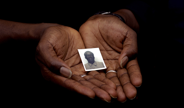 August 2005, New York, N.Y. - A photograph of slain Senegalese livery driver Modou Diop is cradled in the hands of his friend and coworker a day after he was shot to death while working in the Bronx. : News Singles : Jason DeCrow Photojournalist